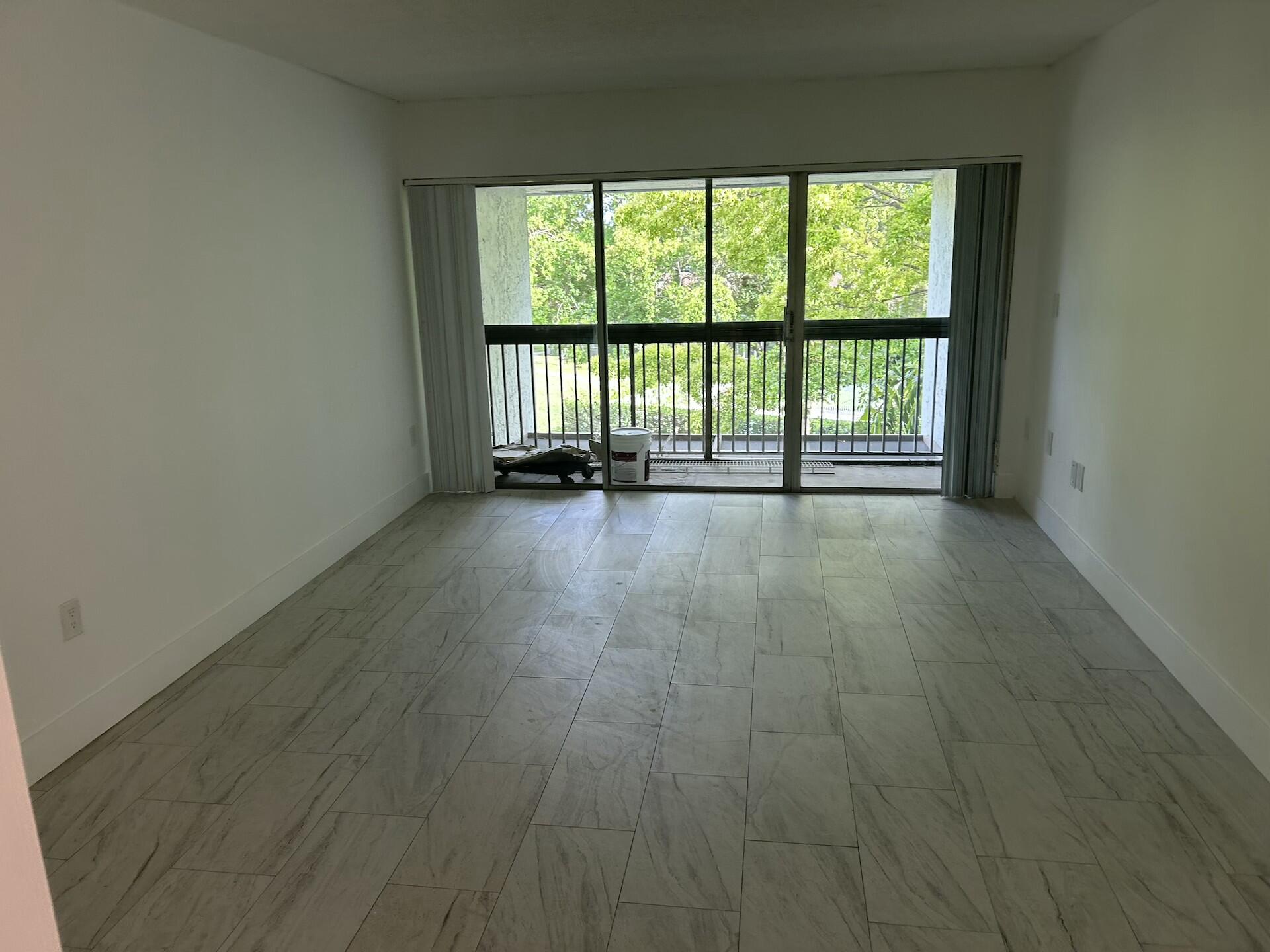 701 North Pine Island Road, Unit 304 Plantation, FL 33324 - Photo 41 of 77 a view of an empty room with wooden floor and a window