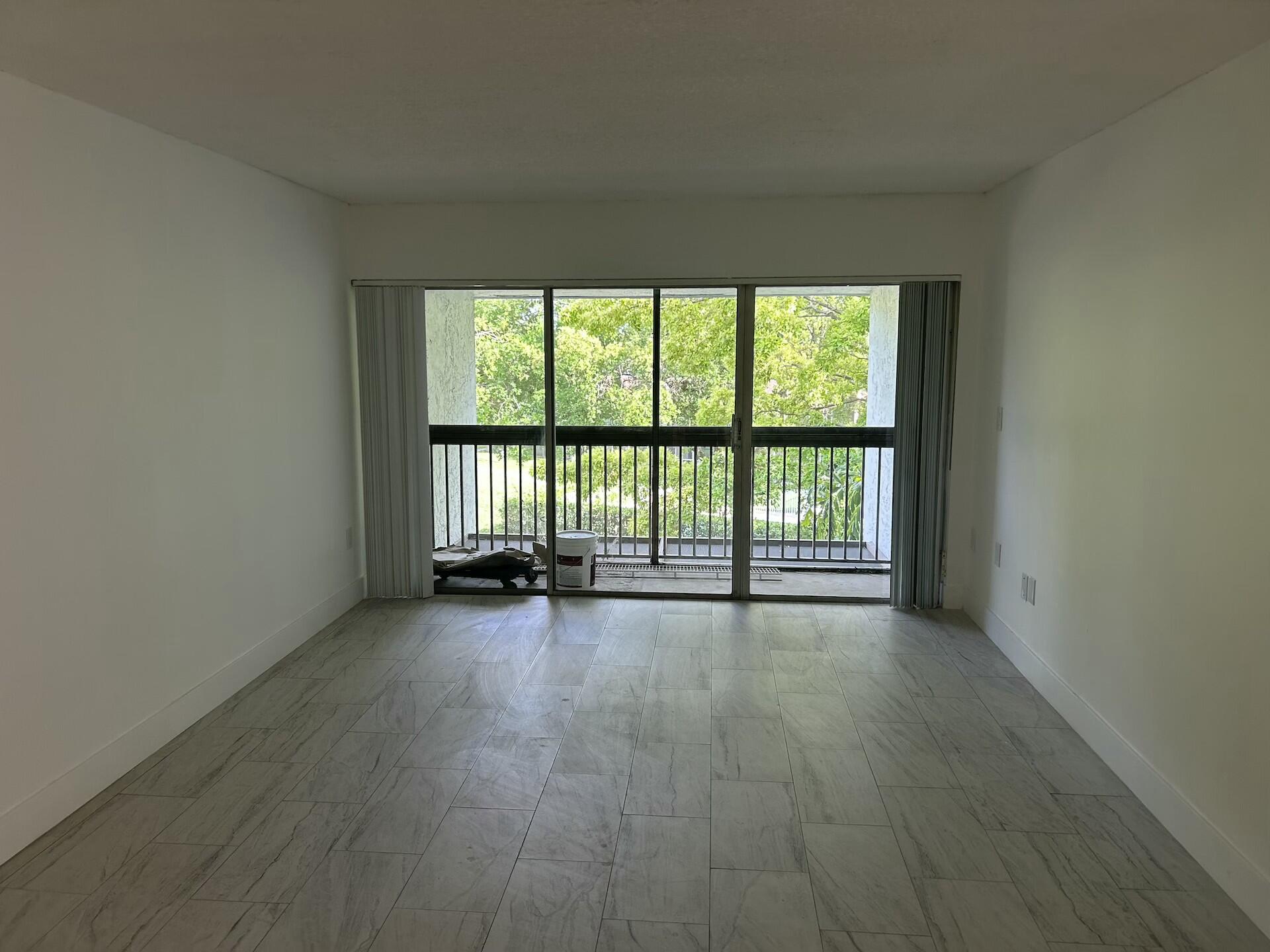 701 North Pine Island Road, Unit 304 Plantation, FL 33324 - Photo 42 of 77 an empty room with wooden floor and balcony