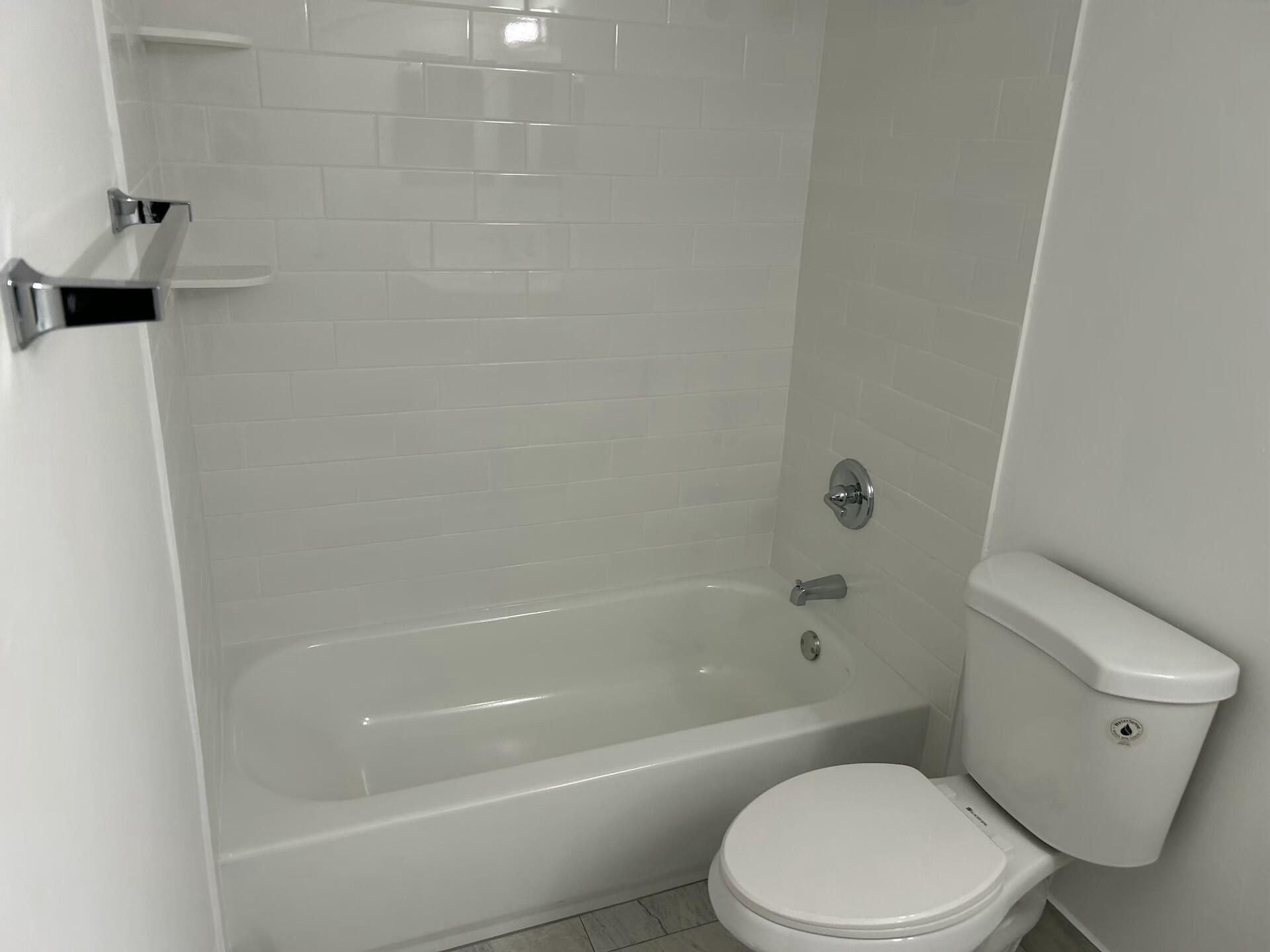 701 North Pine Island Road, Unit 304 Plantation, FL 33324 - Photo 43 of 77 a white toilet and tub sitting next to a bathroom sink