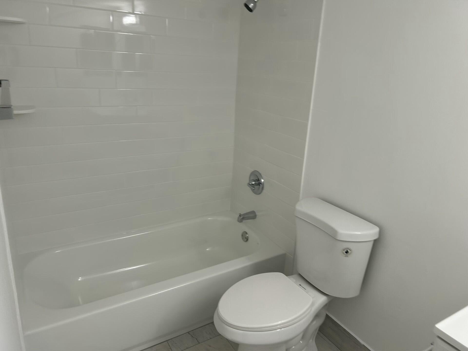 701 North Pine Island Road, Unit 304 Plantation, FL 33324 - Photo 44 of 77 a white toilet and tub sitting next to a bathroom sink