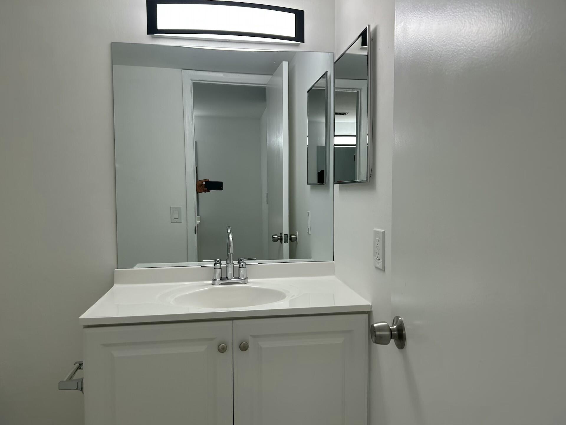 701 North Pine Island Road, Unit 304 Plantation, FL 33324 - Photo 46 of 77 a bathroom with a sink and mirror