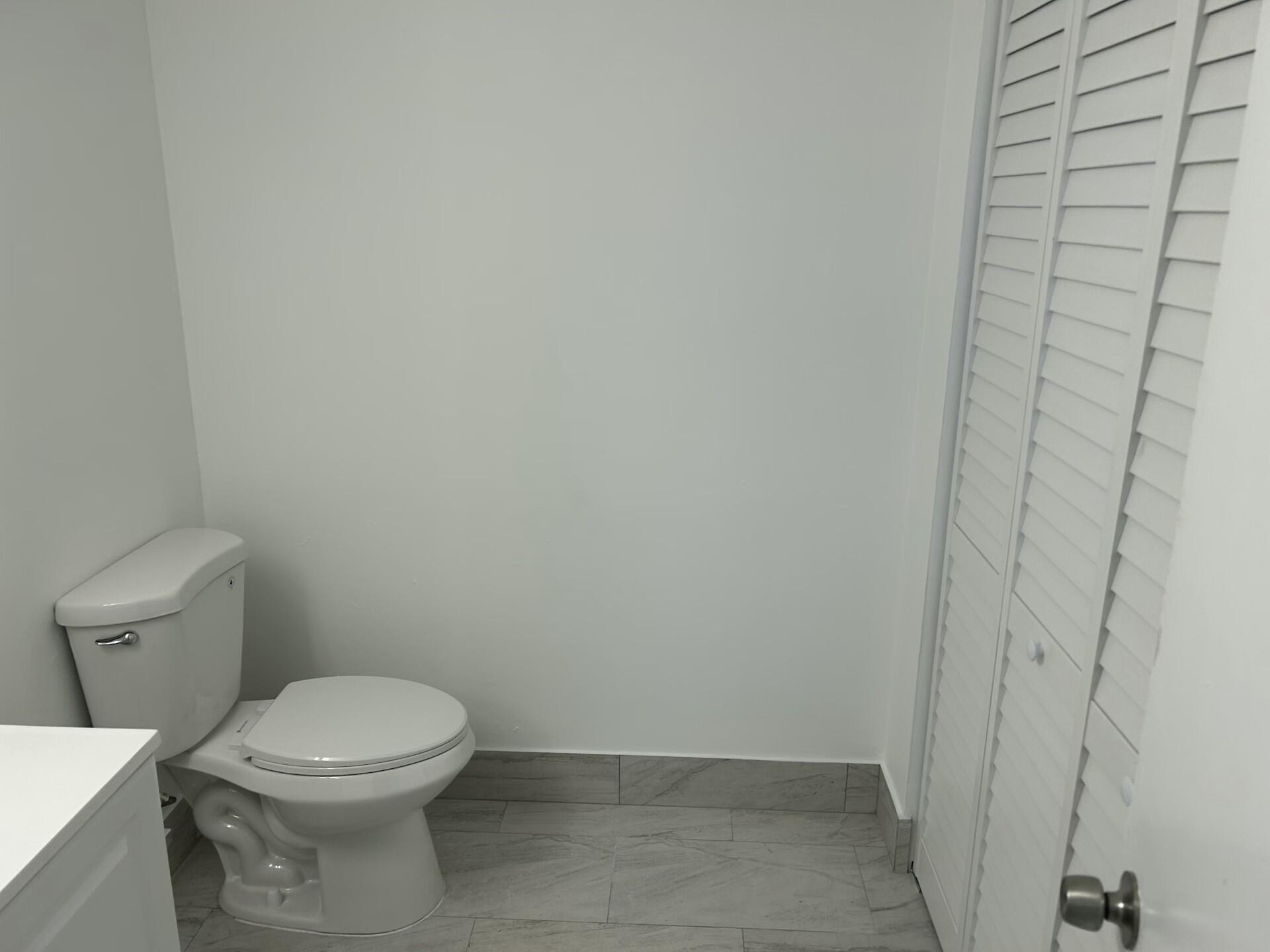 701 North Pine Island Road, Unit 304 Plantation, FL 33324 - Photo 58 of 77 a white toilet sitting next to a white wall