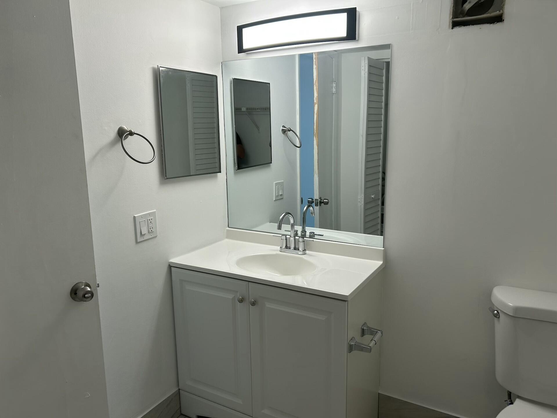 701 North Pine Island Road, Unit 304 Plantation, FL 33324 - Photo 60 of 77 a bathroom with a sink and mirror