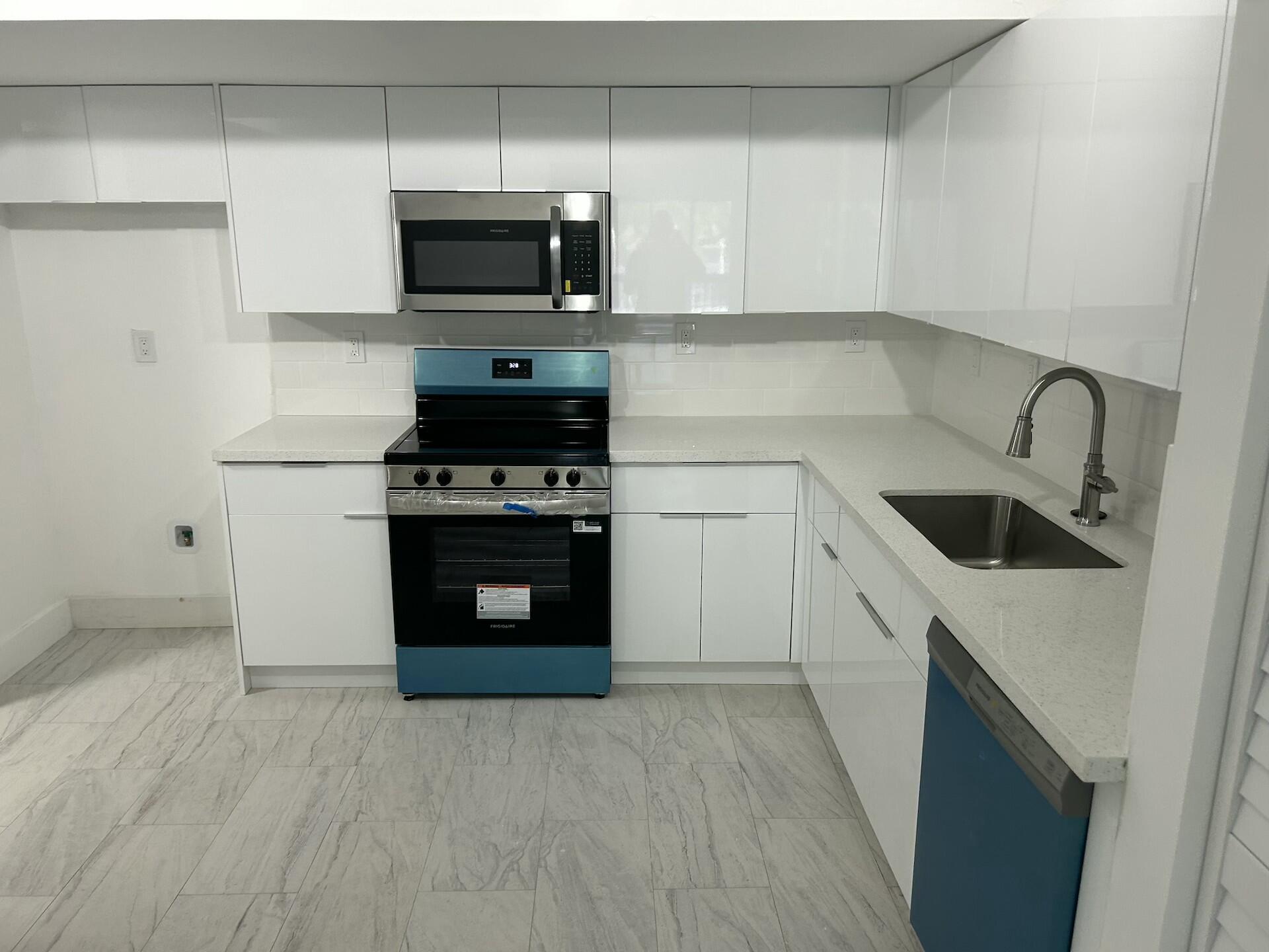 701 North Pine Island Road, Unit 304 Plantation, FL 33324 - Photo 9 of 77 a kitchen with a stove and a microwave