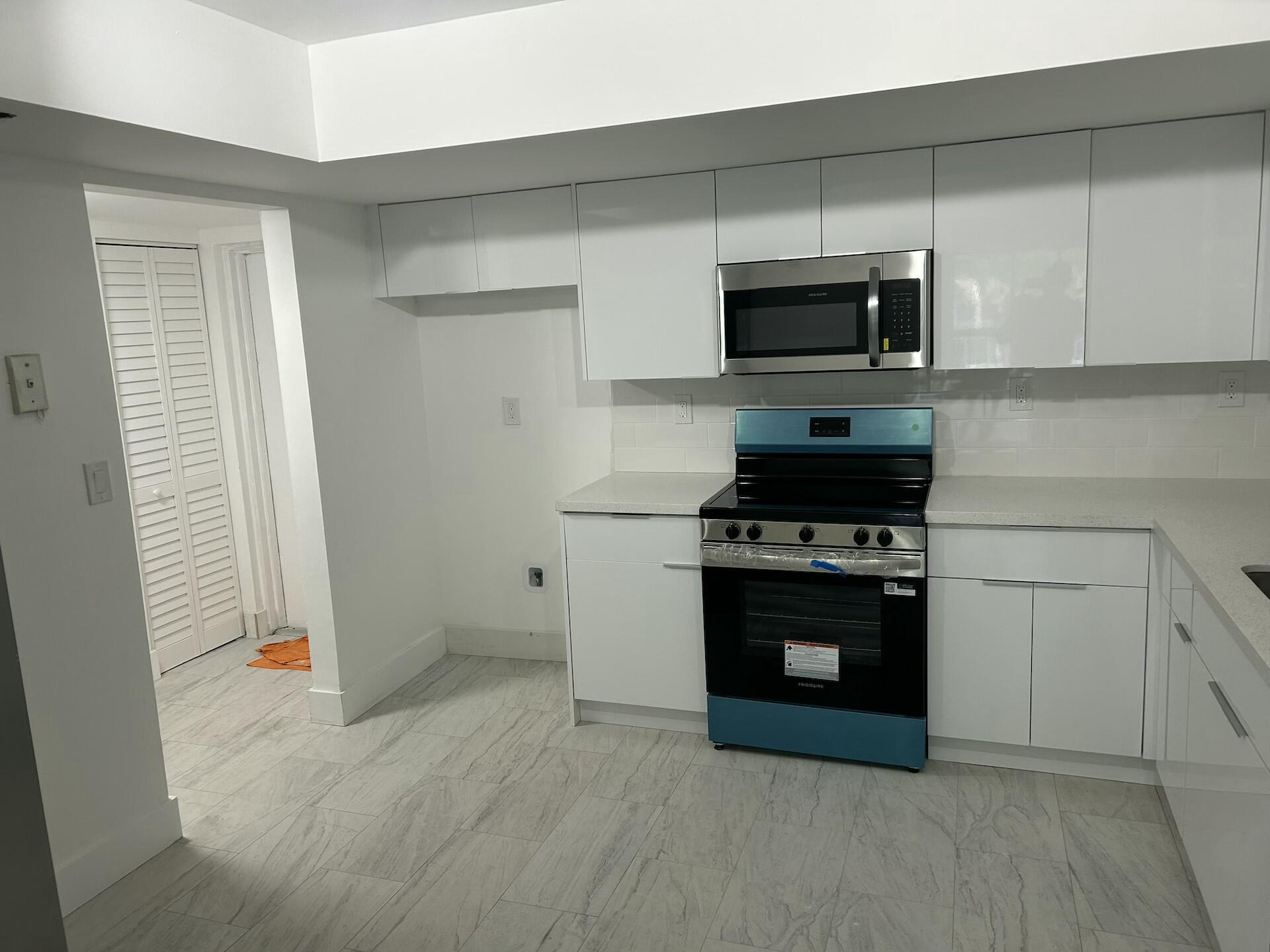 701 North Pine Island Road, Unit 304 Plantation, FL 33324 - Photo 10 of 77 a kitchen with stainless steel appliances a stove a microwave and cabinets