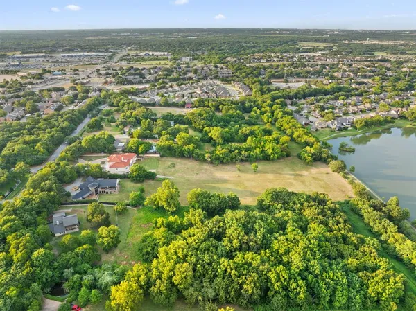 an aerial view of residential houses with outdoor space and trees