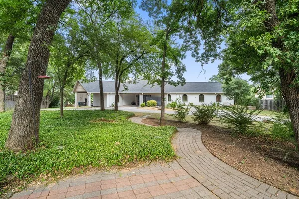 a front view of a house with a yard and shrubs