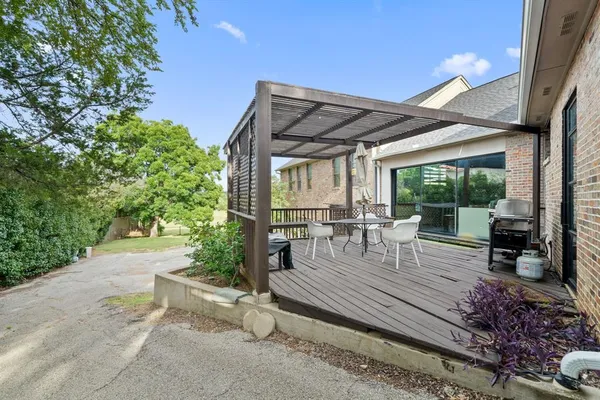 a view of a patio with table and chairs potted plants with wooden floor and fence