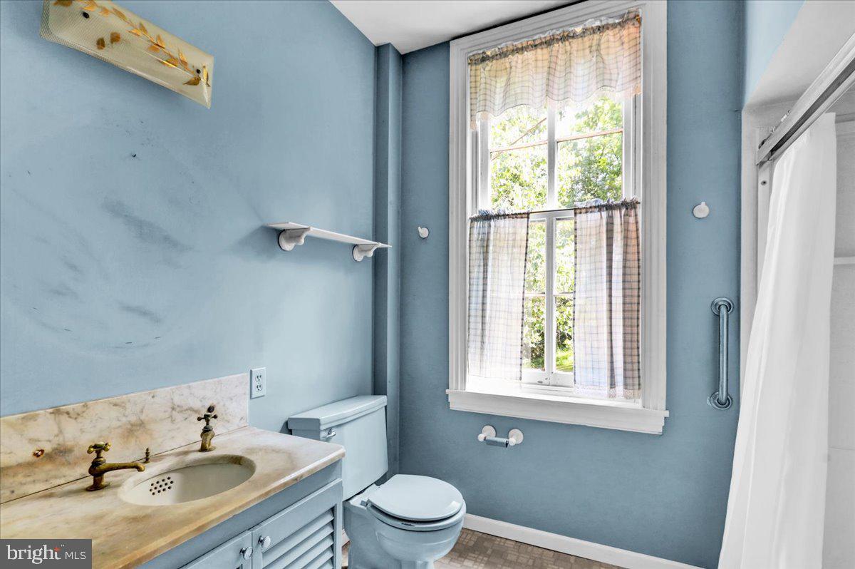 1670 Moselem Spring Road Hamburg, PA 19526 - Photo 29 of 78 a bathroom with a granite countertop sink toilet a large mirror next to a window