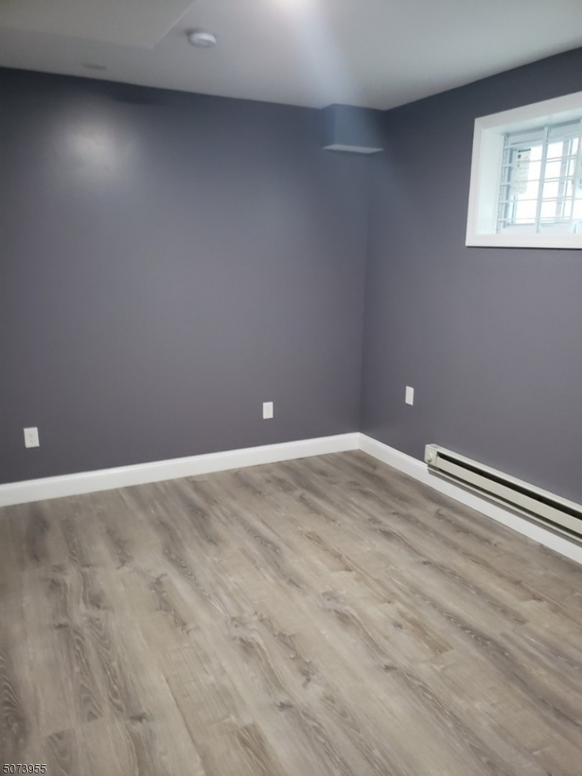 634 Magnolia Avenue, Unit 1 Elizabeth Port, NJ 07206 - Photo 6 of 12 a view of an empty room with wooden floor and a window