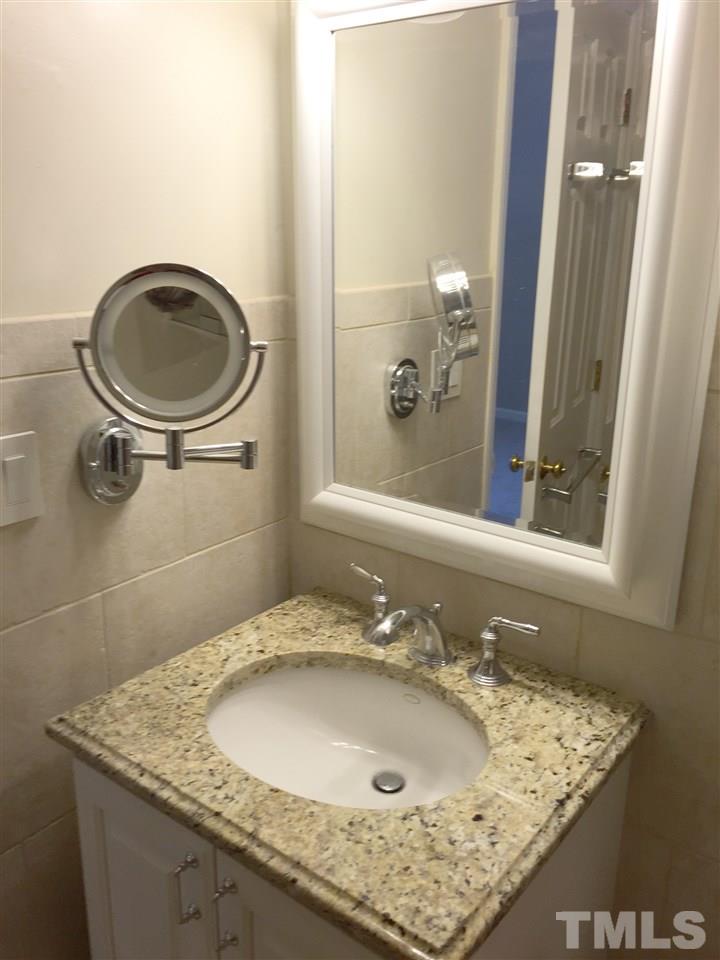 134 Timber Ridge Drive Durham, NC 27713 - Photo 18 of 25 Spa-like in design, the Master Bathroom has heat controlled tile flooring, designer tile bench seating in the glass doored shower, and granite topped vanity.
