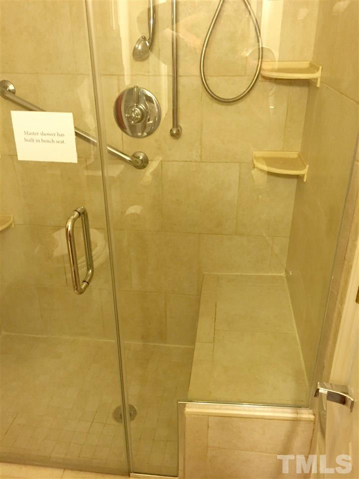 134 Timber Ridge Drive Durham, NC 27713 - Photo 21 of 25 Spa-like in design, the Master Bathroom has heat controlled tile flooring, designer tile bench seating in the glass doored shower, and granite topped vanity.