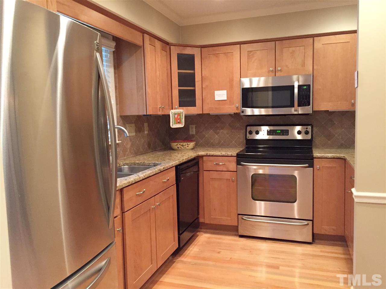 Kitchen features stainless steel appliances; Venetian gold granite countertops; Lowe's cabinets feature soft close drawers and track drawers; designer tile backsplash and flooring; pass through to dining area;