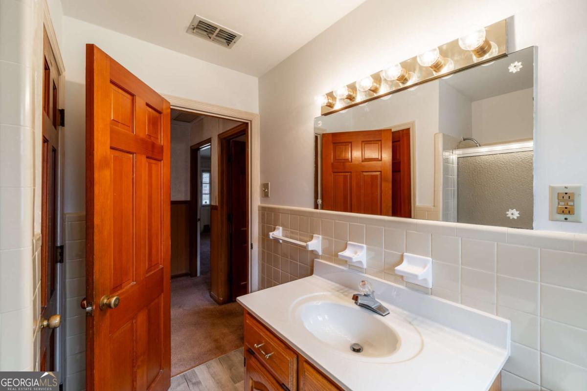 389 Ashton Drive Athens, GA 30606 - Photo 47 of 72 a bathroom with a sink a mirror and a shower