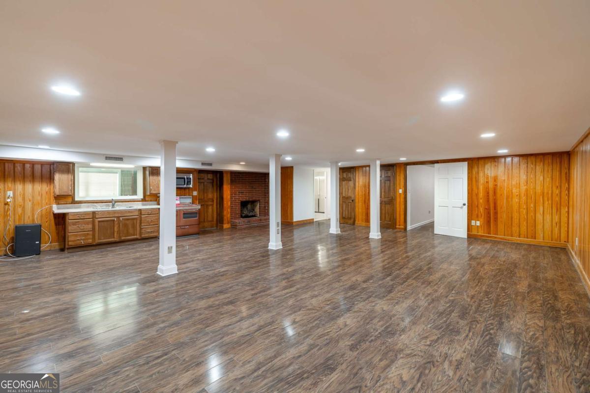 389 Ashton Drive Athens, GA 30606 - Photo 54 of 72 a view of an empty room with wooden floor and a kitchen