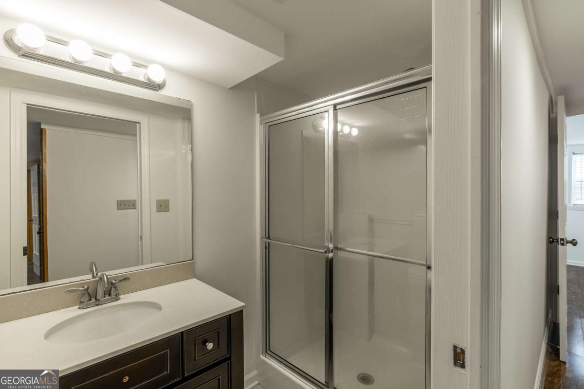 389 Ashton Drive Athens, GA 30606 - Photo 59 of 72 a bathroom with a shower sink vanity and mirror
