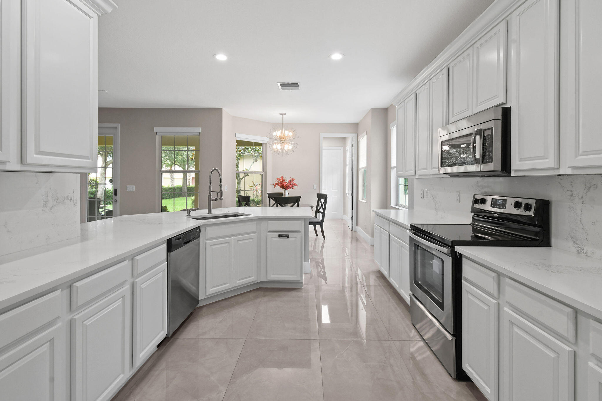 111 Tullamore Avenue Jupiter, FL 33458 - Photo 21 of 64 a kitchen with stainless steel appliances granite countertop a stove a sink and a microwave