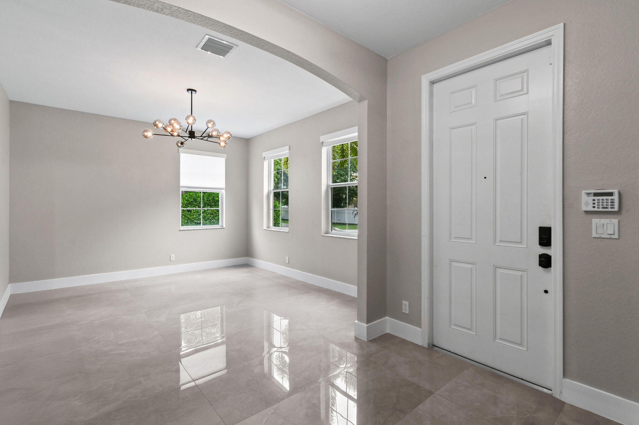 111 Tullamore Avenue Jupiter, FL 33458 - Photo 9 of 64 an empty room with windows and chandelier fan