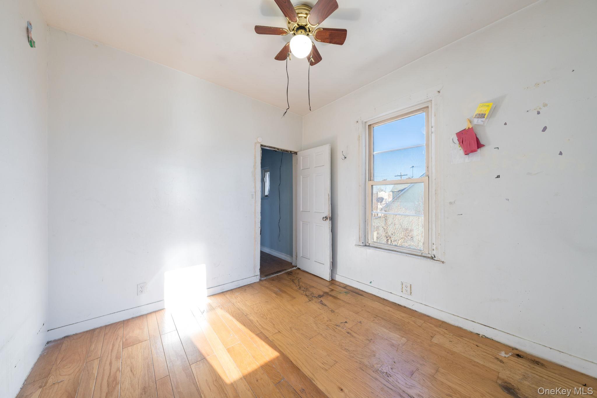 2214 Hermany Avenue Bronx, NY 10473 - Photo 14 of 43 a view of an empty room with window and wooden floor