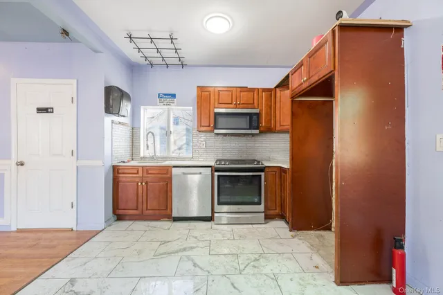 a large kitchen with stainless steel appliances granite countertop a refrigerator and a sink