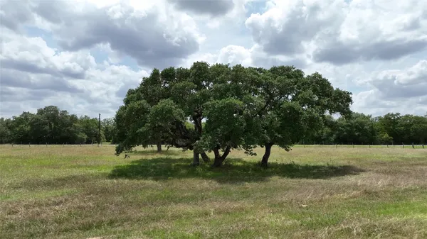 a sign board with a house in the background
