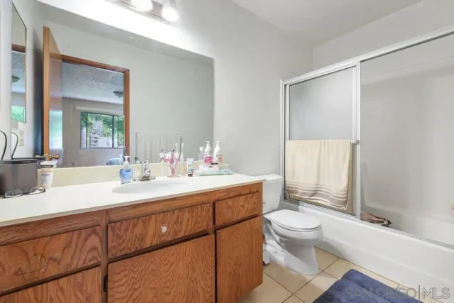 a bathroom with a double vanity sink toilet mirror and shower