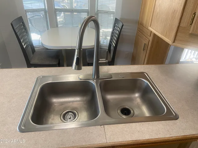 a kitchen that has a sink stainless steel appliances a refrigerator and a sink