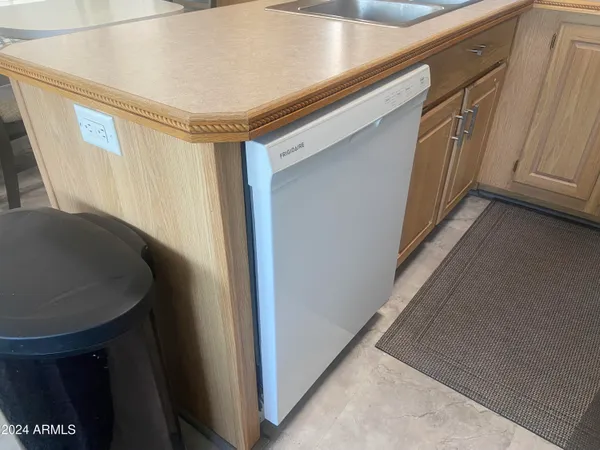 a room with a washer dryer and wooden cabinets