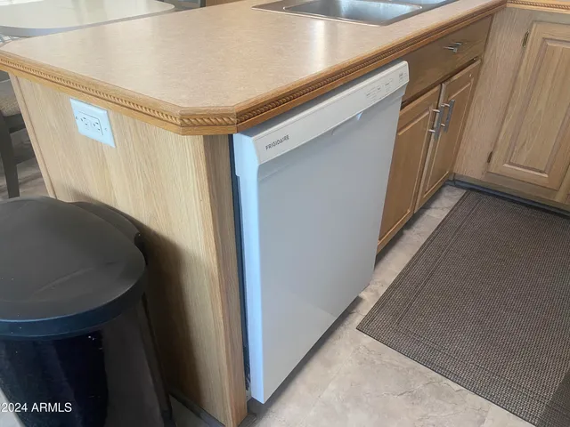 a room with a washer dryer and wooden cabinets