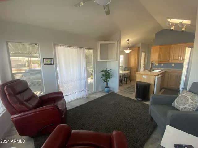 a living room with furniture a large window and stainless steel appliances