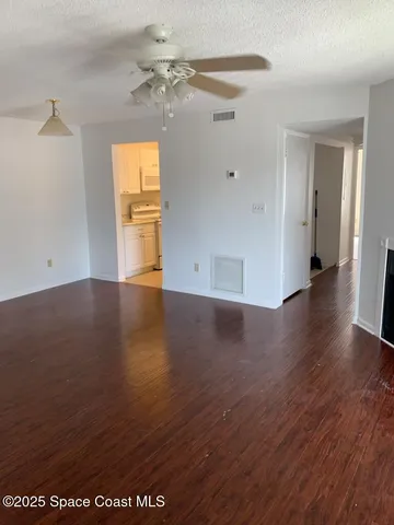 a view of a room with wooden floor and a window