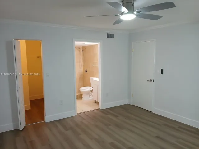 a view of a room with wooden floor and a ceiling fan