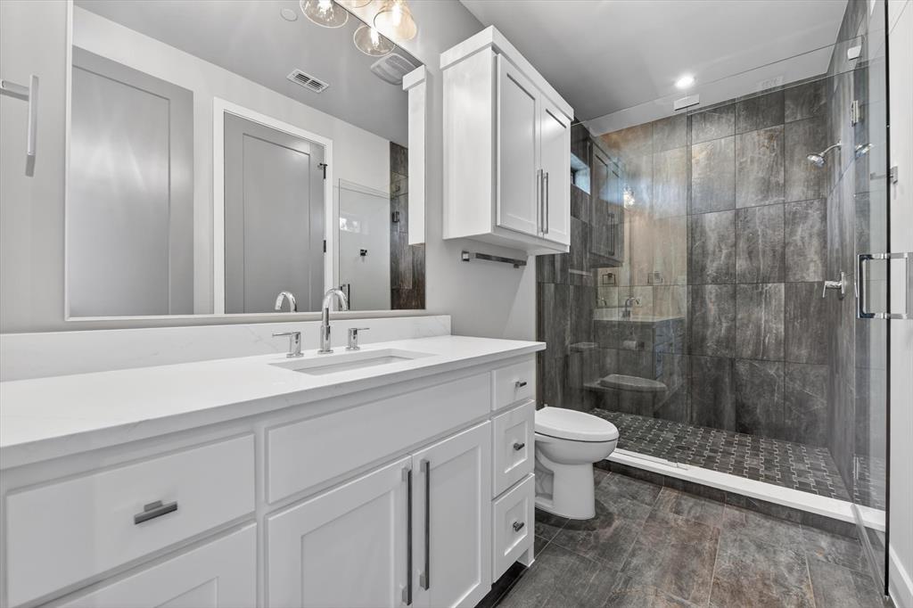 11028 Edgemere Road Dallas, TX 75230 - Photo 32 of 40 Bathroom featuring a white vanity with a rectangular undermount sink and polished chrome faucet
