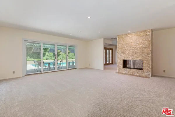 an empty room with fireplace and window