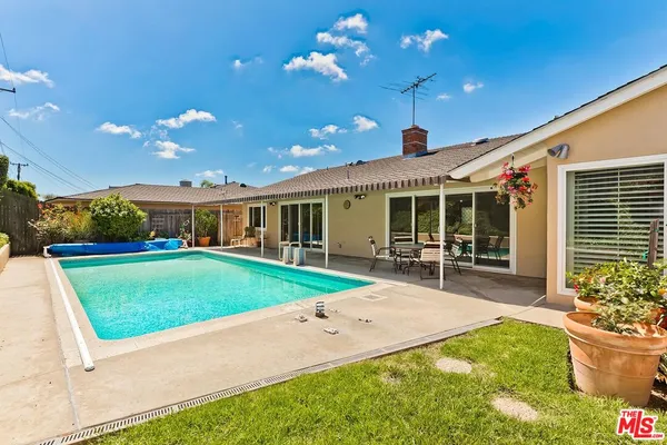 a front view of a house with a garden and patio