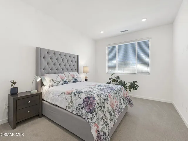 a bedroom with a bed and a large window