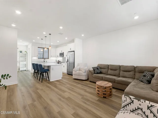 a living room with furniture and kitchen view