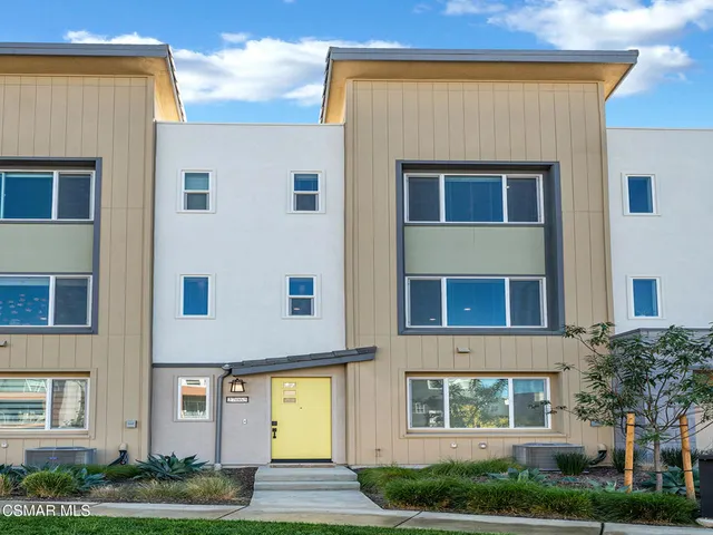 a front view of an apartment building with a yard