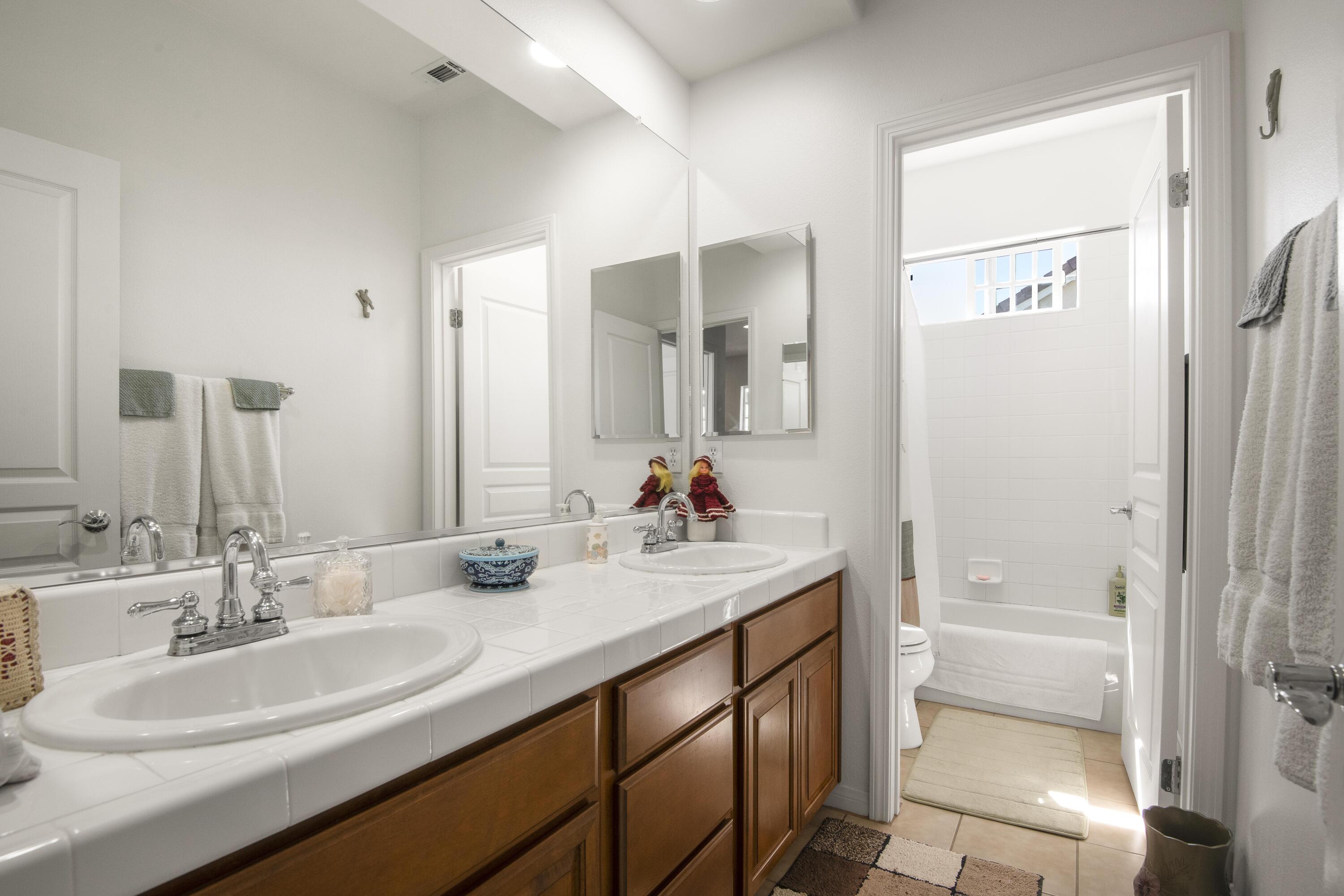 225 Silver Oak Drive Paso Robles, CA 93446 - Photo 18 of 22 a bathroom with a double vanity sink mirror double shower and a bathtub