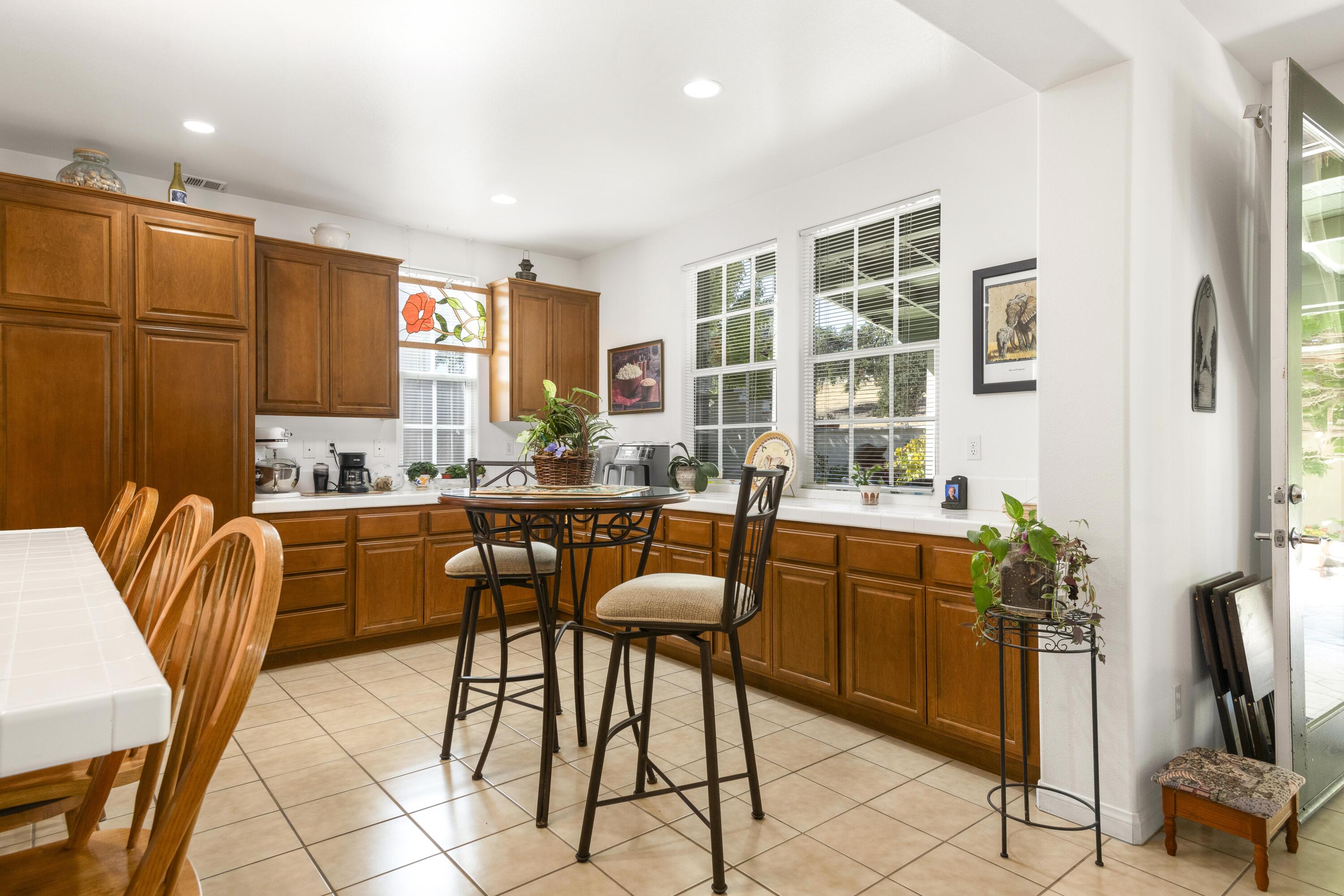 225 Silver Oak Drive Paso Robles, CA 93446 - Photo 9 of 22 a kitchen with stainless steel appliances kitchen island granite countertop a table and chairs in it