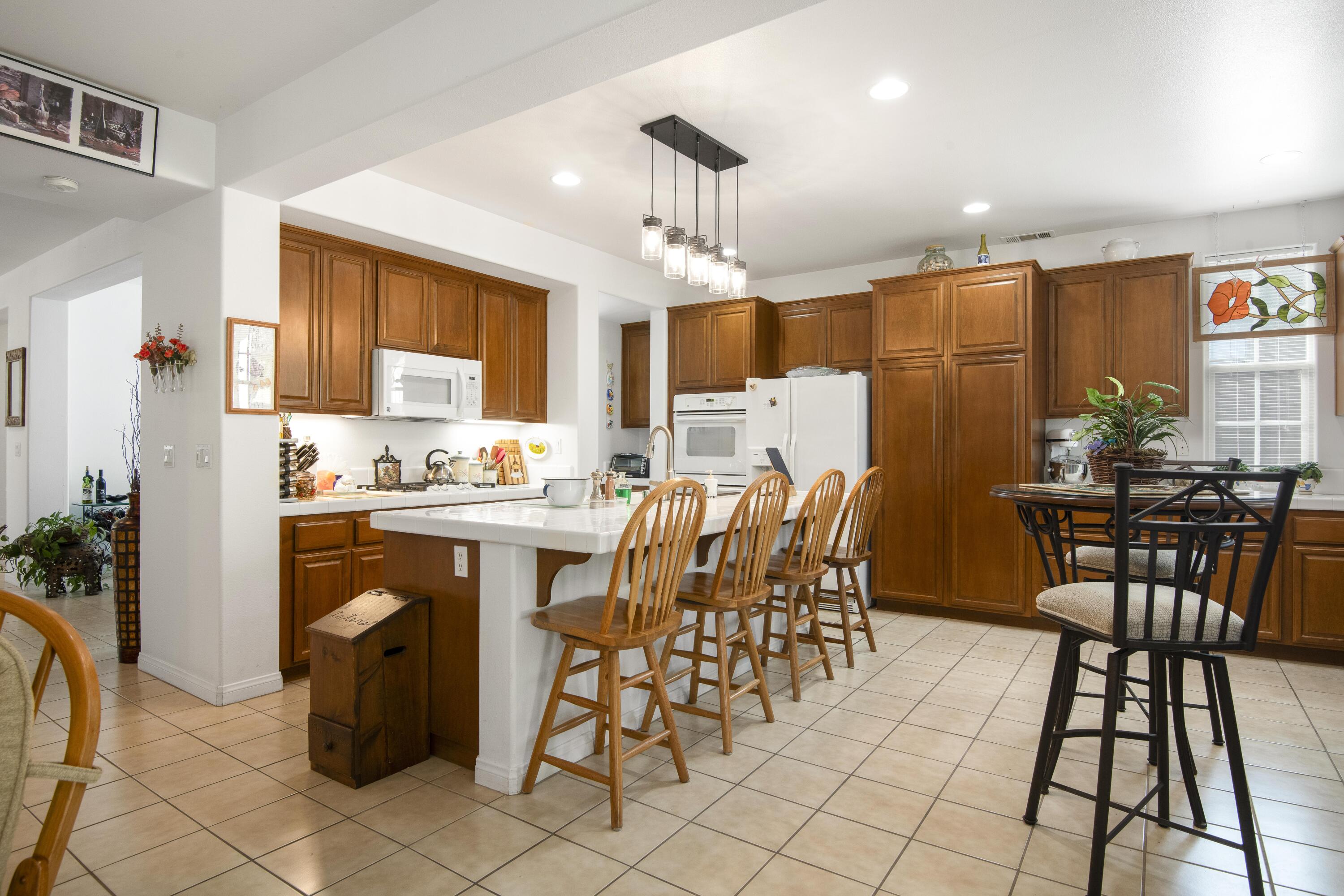 225 Silver Oak Drive Paso Robles, CA 93446 - Photo 10 of 22 a kitchen with a table chairs refrigerator and cabinets