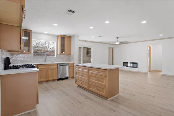 an empty room with wooden floor chandelier and windows