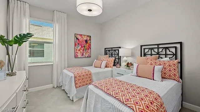a bedroom with two beds and a window with potted plant
