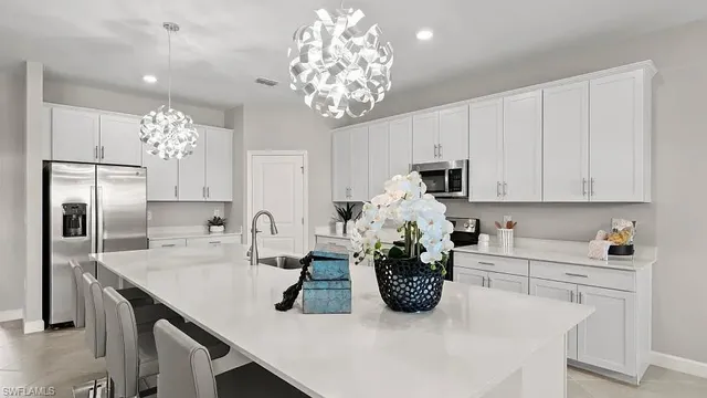a kitchen with kitchen island granite countertop a sink white cabinets and stainless steel appliances