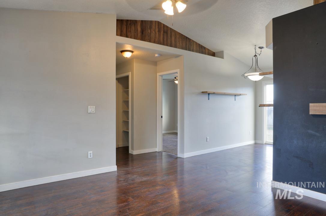 4911 Buffalo Grass Avenue Caldwell, ID 83607 - Photo 3 of 15 Unfurnished room with ceiling fan, lofted ceiling, and dark wood-type flooring
