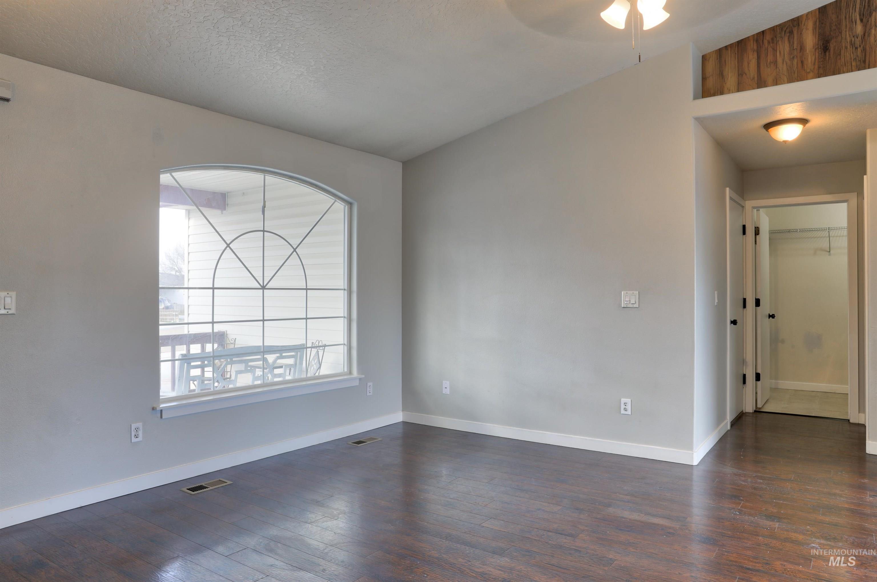 4911 Buffalo Grass Avenue Caldwell, ID 83607 - Photo 5 of 15 Spare room featuring dark wood finished floors, a textured ceiling, and a ceiling fan