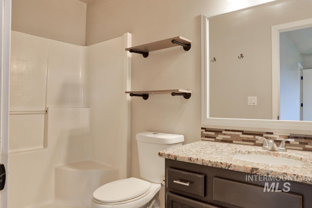 4911 Buffalo Grass Avenue Caldwell, ID 83607 - Photo 7 of 15 Full bathroom featuring vanity, tasteful backsplash, and a shower stall