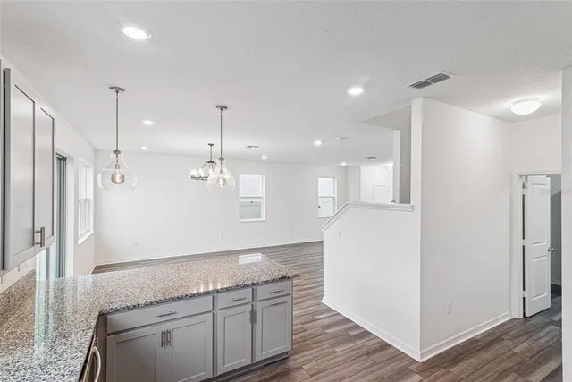 a open kitchen with kitchen island white cabinets and stainless steel appliances