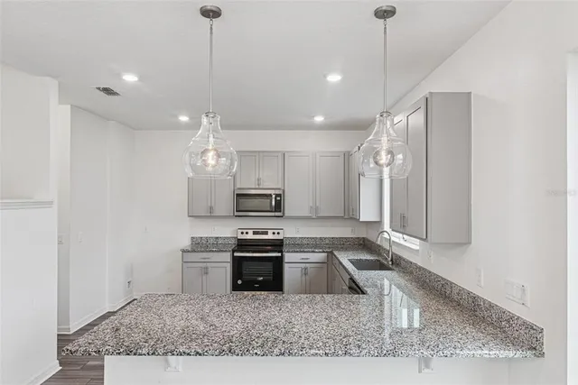 a kitchen with kitchen island a stove a sink and a counter top space