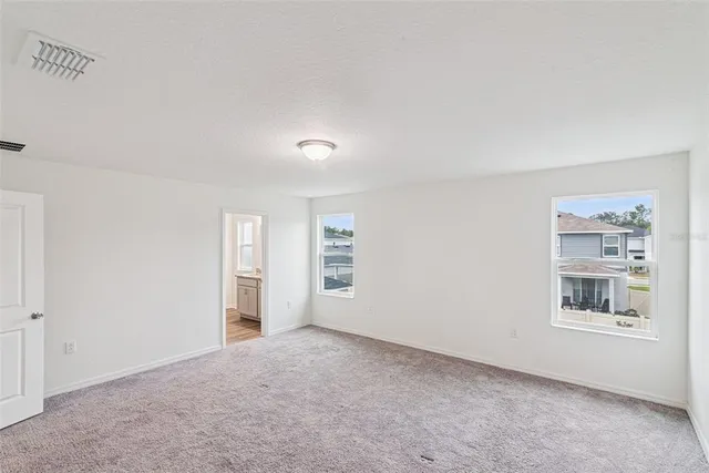 an empty room with windows and closet